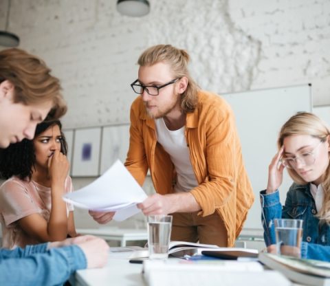 group-of-upset-students-sitting-at-the-table-with-E5YW9L4-min